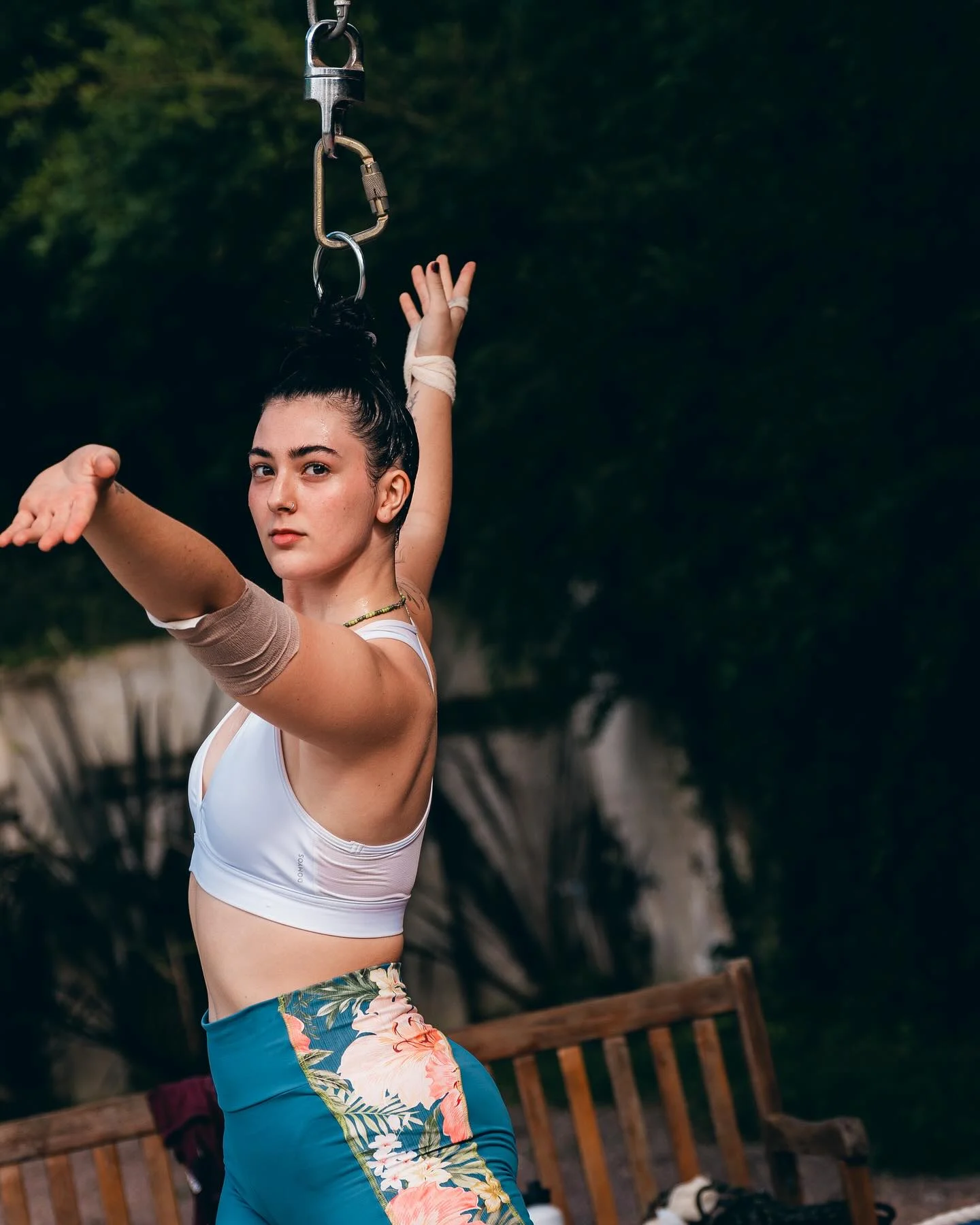 Laís em treino de circo, junto a uma corda, usando top branco